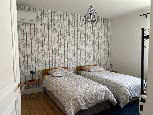 a bedroom with two beds and a wallpaper at BELISAMA in Molsheim