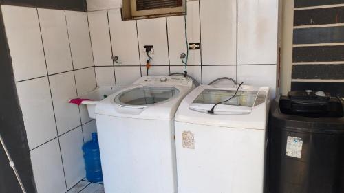 a washing machine in a room with a trash can at Nomah Hostel in Sao Jose do Rio Preto