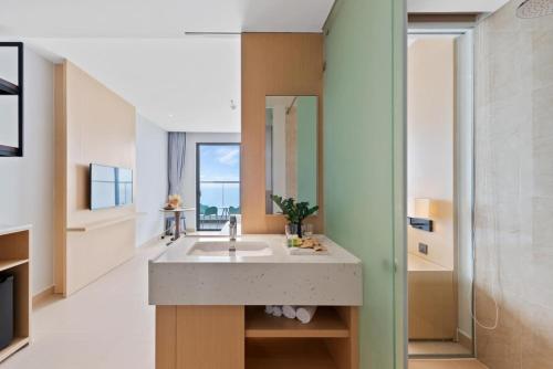 a bathroom with a sink and a mirror at Arena Lucky Condotel in Cam Ranh International Airport