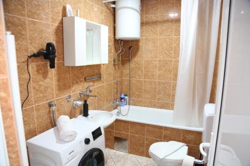 a bathroom with a sink and a toilet and a tub at City Apartman 103 in Bosanski Brod