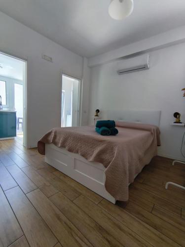 a white bedroom with a bed with a brown blanket at La Terrazza dell'Abate in Maiori