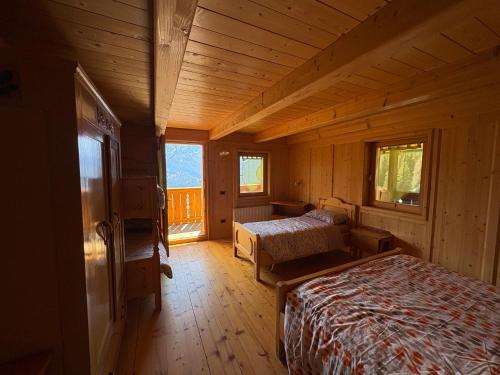 a bedroom with two beds in a wooden cabin at Ceda Fiore in Costalta