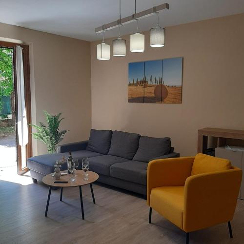 a living room with a blue couch and a table at Tuscany Hills - Comfort 10 minutes from Montepulciano and Pienza in Torrita di Siena