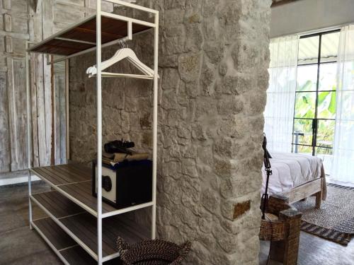 a room with a white book shelf against a stone wall at Sun Moon Star Villas in Jarakan