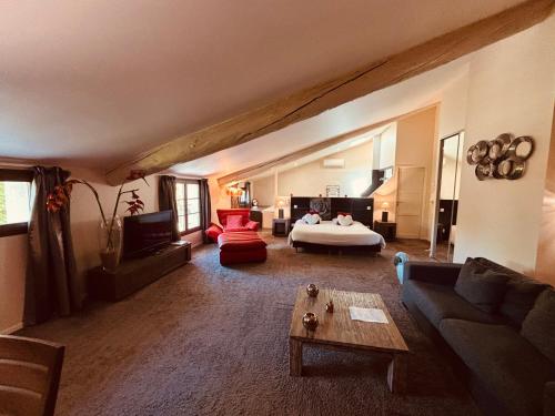 a large living room with a bed and a couch at Au Lavoir in Colombiers