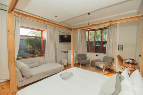 a bedroom with a bed and a living room at The Valley Escape - Executive Suite in Gqeberha
