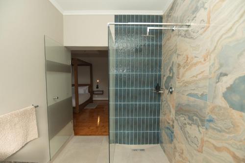 a glass shower in a bathroom with a hallway at The Valley Escape - Executive Suite in Gqeberha