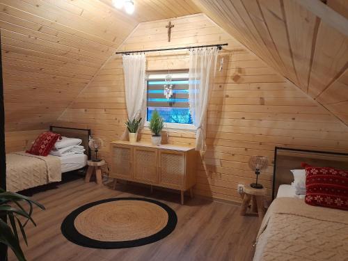 a room with two beds and a window in a cabin at Domki pod szybowiskiem in Lesko