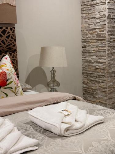 a bed with white towels on it with a lamp at Amira Boutique Villa in Empangeni