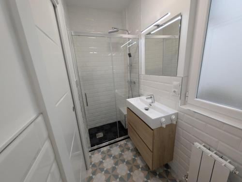 a white bathroom with a sink and a shower at Alojamientos Bahia de Santoña 4 in Santoña
