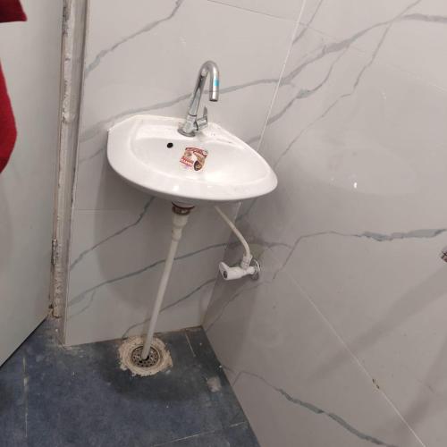 a bathroom with a white sink in a wall at Atlas blue hotel in Bathinda
