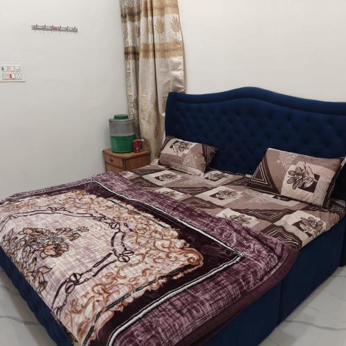 a bed with a purple bedspread and pillows on it at Atlas blue hotel in Bathinda
