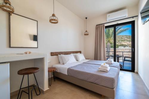 a hotel room with a bed and a balcony at Prasonisi Lighthouse Asimenis in Prasonisi