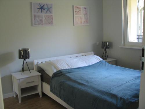 ウケンチンにあるBlue Mare Apartament u Kwiatkówのベッドルーム1室(ベッド1台、ナイトスタンド2台、ランプ2つ付)