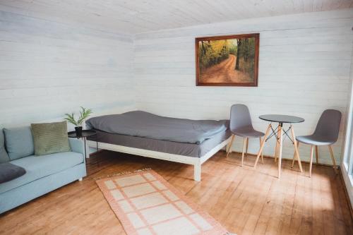 a room with a bed and a couch and a table at Peaceful Forest Cabin in Nature in Paluküla