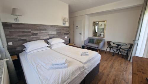 a bedroom with a large white bed and a chair at Casa Comilor in Şurdeşti
