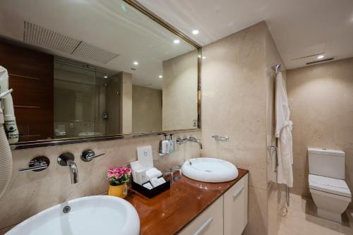 a bathroom with a sink and a toilet and a mirror at The Venue Al Harithia Hotel in Medina