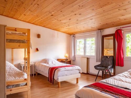 a bedroom with two beds and a wooden ceiling at L'Abeille-Vie in Tréziers