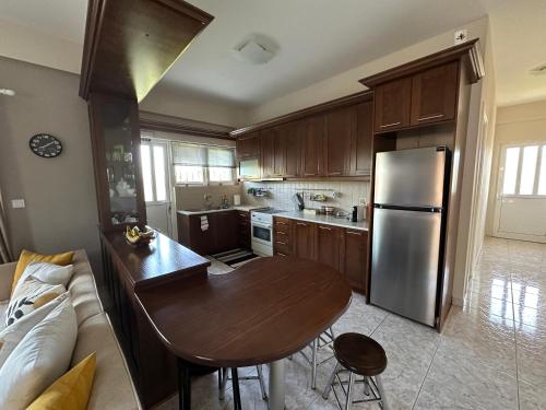 a kitchen with a table and a stainless steel refrigerator at Siamos Villa in Vonitsa