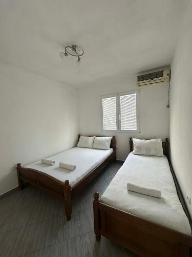 two beds in a room with white walls at Apartmani Glory Sutomore in Sutomore