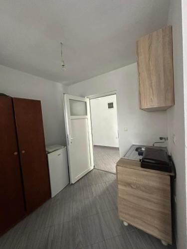 a room with a kitchen with a refrigerator and a door at Apartmani Glory Sutomore in Sutomore