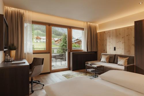 a hotel room with a bed and a desk at Hotel La Majun in La Villa