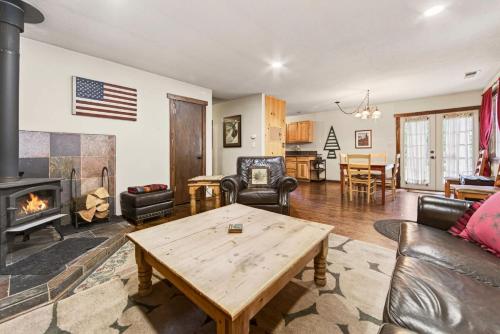 a living room with a table and a fireplace at The Rustic Pine 2BDR Cabin in Tahoma