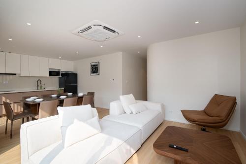 a living room with a white couch and a kitchen at Haus 42 in Bangkok