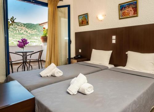 a hotel room with two beds with towels on them at Hotel Elena Syvota in Syvota