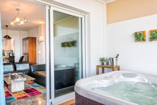 a bathroom with a tub and a living room at Carvajal Luxury Apartments in Fuengirola