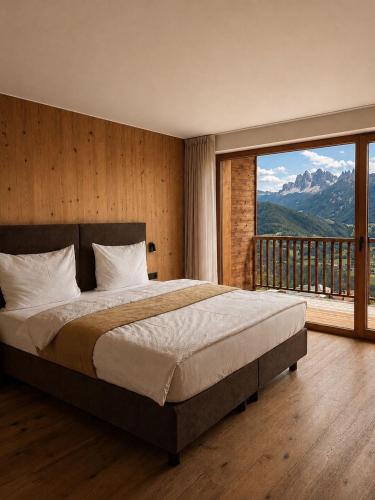 ein Schlafzimmer mit einem großen Bett und einem großen Fenster in der Unterkunft Kierhof Chalets in Feldthurns