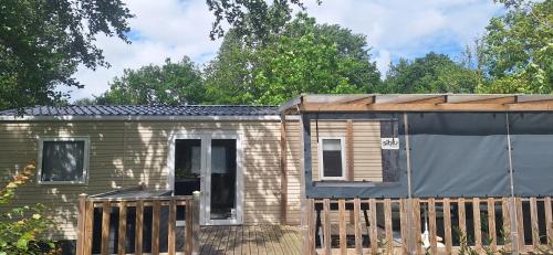 a small brick house with a wooden fence at Chalet Lauwersoog mét airco! in Lauwersoog