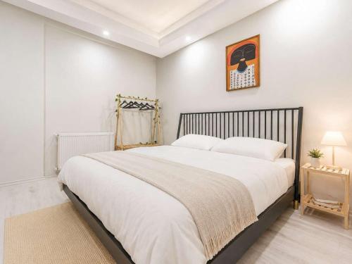 a bedroom with a large bed with white sheets at Maxihomes Elissa in Antalya