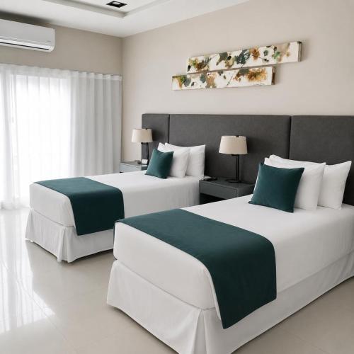 two beds in a hotel room with white and green at Hotel Boutique Gualamba in General Pinedo