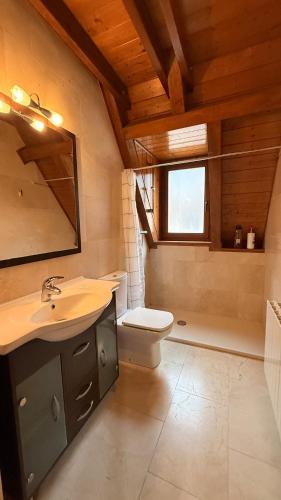 ein Badezimmer mit Waschbecken, Toilette und Fenster in der Unterkunft Montlude in Bossost