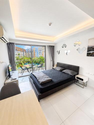a bedroom with a large bed and a balcony at Laguna Beach Resort 2 Pattaya in Jomtien Beach