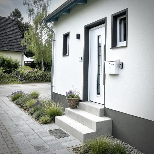 a white house with stairs leading to a door at Koje47 in Scharbeutz