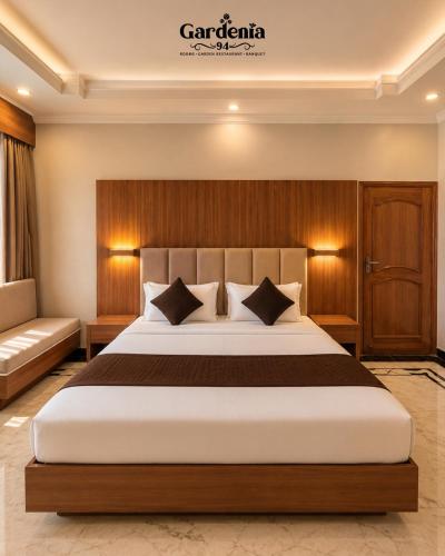 a bedroom with a large bed and a couch at Hotel gardenia inn in Gwalior