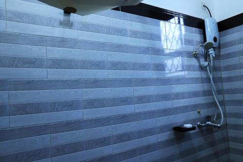a bathroom with a blue and white tile wall at Kingram Apartments in Entebbe