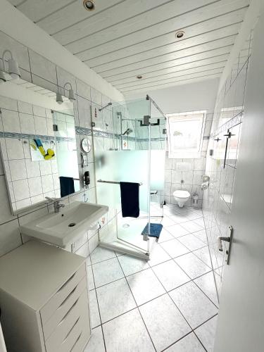 a white bathroom with a sink and a toilet at Ferien-Whg Stünkel nahe Steinhuder Meer mit Garten und Balkon in Steinhude
