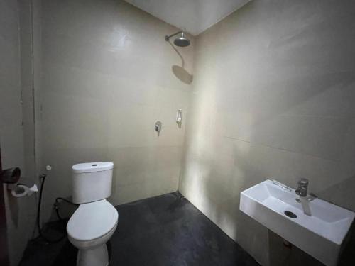 a bathroom with a white toilet and a sink at Melati Hotel central kuta mandalika in Kuta Lombok