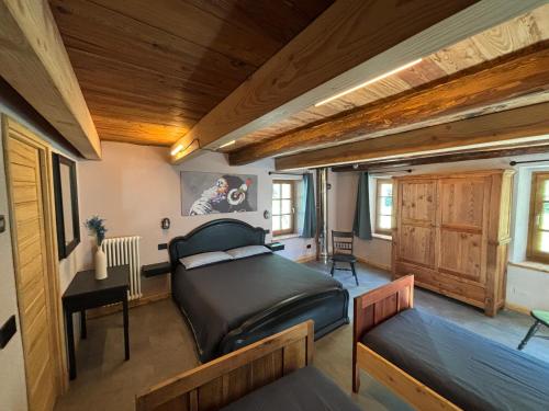 a bedroom with a bed in a room with wooden ceilings at Riverside Room Elia Family friendly apartment in Pontboset