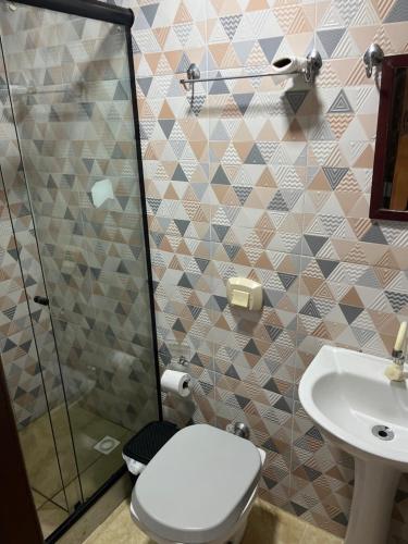 a bathroom with a toilet and a sink at Espaço Colibri in Teresópolis
