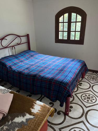 a bedroom with a bed with a blue blanket on it at Espaço Colibri in Teresópolis