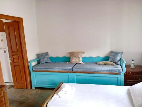 a bed with a blue bed frame in a room at Lefkiani House in Katapola