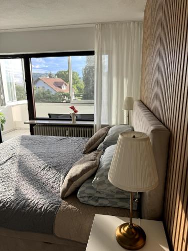 a bedroom with a bed with a lamp and a window at Isaak Appartement Harmonie in Küssaberg