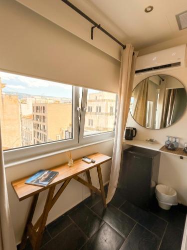 a room with a table and a large window at Elite Ermou Suites in Athens