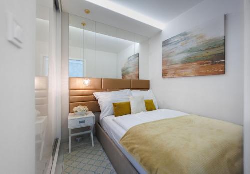 a small bedroom with a bed and a night stand at Second Home Luxury Apartman in Siófok