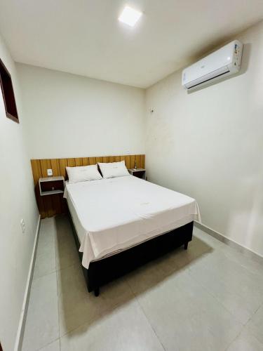 a bedroom with a large white bed in a room at Flat completo em condomínio in Camocim