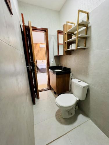 a bathroom with a toilet and a sink at Flat completo em condomínio in Camocim